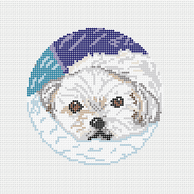 Needlepoint canvas of a white Maltese wearing a navy blue winter hat with a snowflake border, circular ornament format